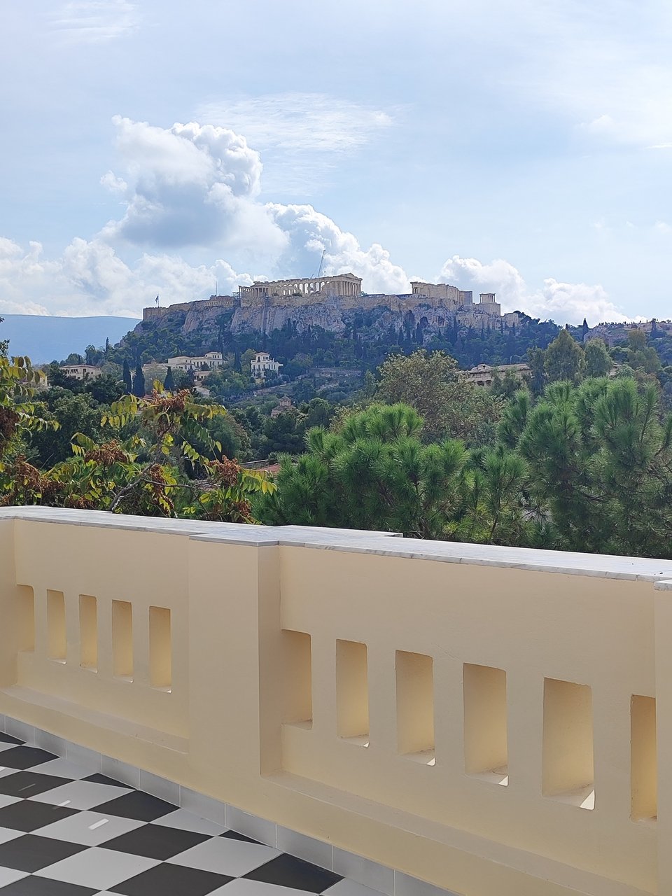 Η μεγάλη βεράντα με κτιστό στηθαίο με θέα προς την Πλάκα και την Ακρόπολη