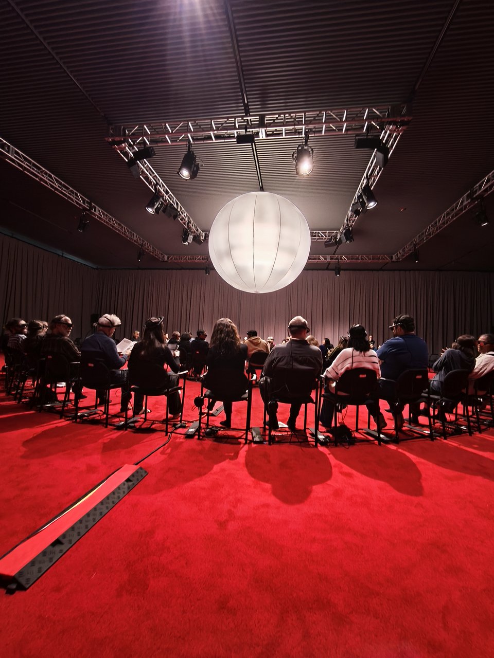 Eικόνα μέσα από την αίθουσα, με τους ξυπόλυτους θεατές, την κόκκινη μοκέτα, το λευκό μπαλόνι / iefimerida Κατερίνα Ι. Ανέστη