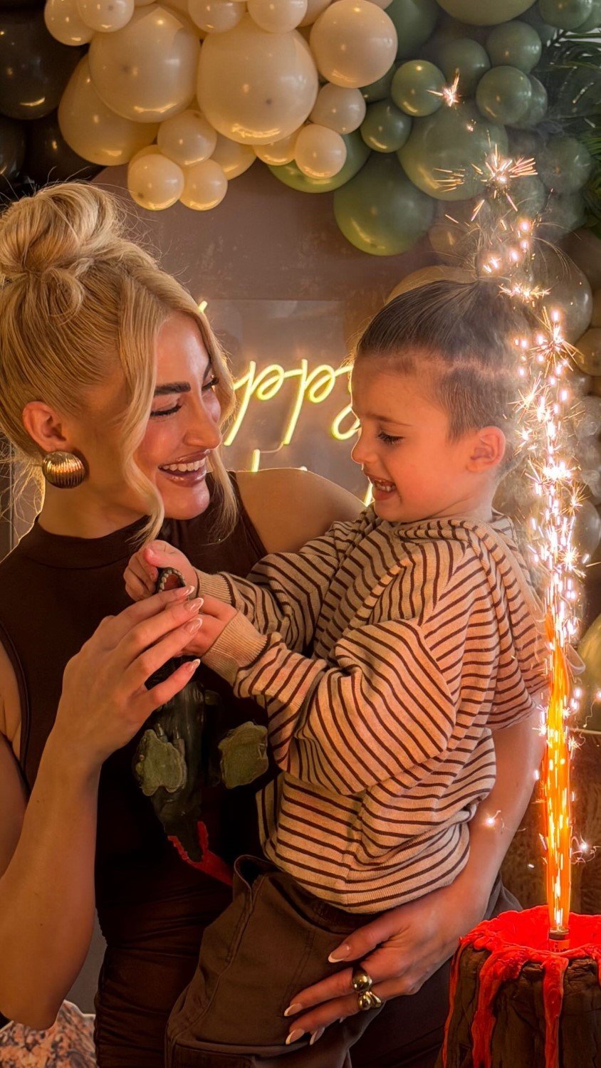 Χαμογελαστή η Ιωάννα Τούνη κρατώντας αγκαλιά τον γιο της