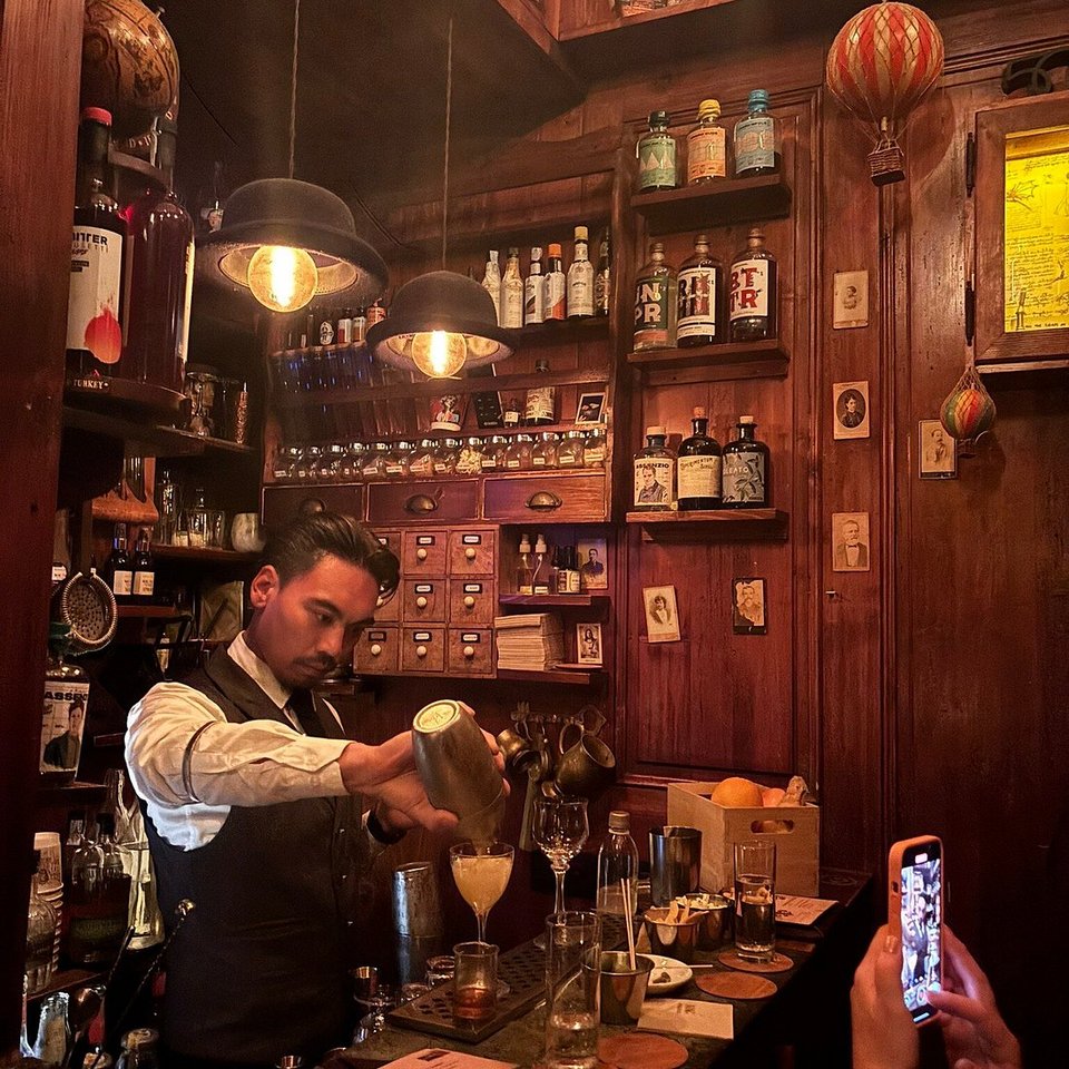 Παρά το απειροελάχιστο μέγεθός του, το Backdoor 43 έχει μια απαράμιλλη γοητεία. Ο χώρος των 4 τετραγωνικών μέτρων διαθέτει εντυπωσιακά ψηλά ταβάνια, περιμετρικά στολισμένα με σειρές από σπάνια ουίσκι και κιτρινισμένες vintage φωτογραφίες / INSTAGRAM