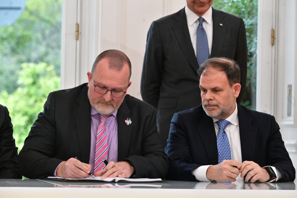 O κ. Gavin Lewis της Chevron υπογράφει τη συμφωνία υπό το βλέμμα του Άρη Στεφάτου, επικεφαλής της Ελληνικής Διαχειριστικής. Εταιρείας Υδρογονανθράκων και Ενεργειακών Πόρων Α.Ε. (ΕΔΕΥΕΠ)  