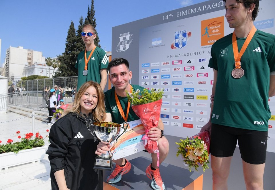 Η Νάνση Βέρρα, Chief Legal, Regulatory &amp; Compliance Officer της Allwyn Hellas, βραβεύει τον Ορφέα Ιωάννου, που αναδείχθηκε νικητής στους άνδρες στον Αγώνα Δρόμου των 5 χλμ. Allwyn 