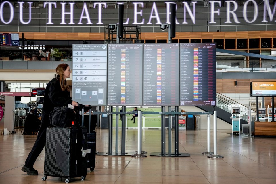 Επιβάτης περνάει δίπλα από οθόνη που εμφανίζει ακυρωμένες πτήσεις στο αεροδρόμιο Βερολίνου-Βρανδεμβούργου / Φωτογραφία: AP / Ebrahim Noroozi
