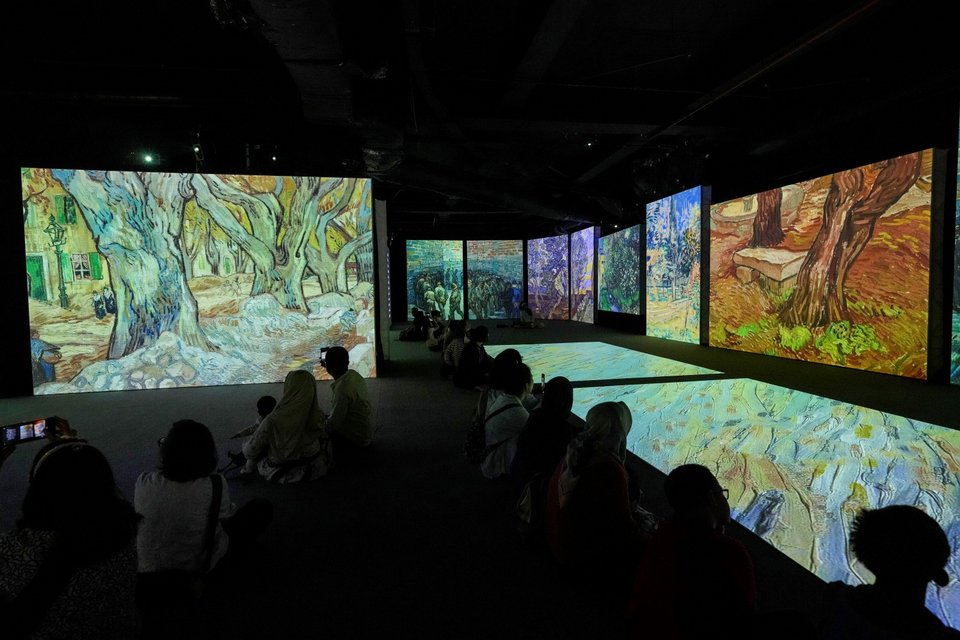 Άνθρωποι παρακολουθούν οπτικό κινούμενο μοντάζ αξιόλογων έργων του καλλιτέχνη Βίνσεντ βαν Γκογκ στην έκθεση "Van Gogh Alive", Τζακάρτα, Ινδονησία  /Φωτογραφία: AP /Tatan Syuflana