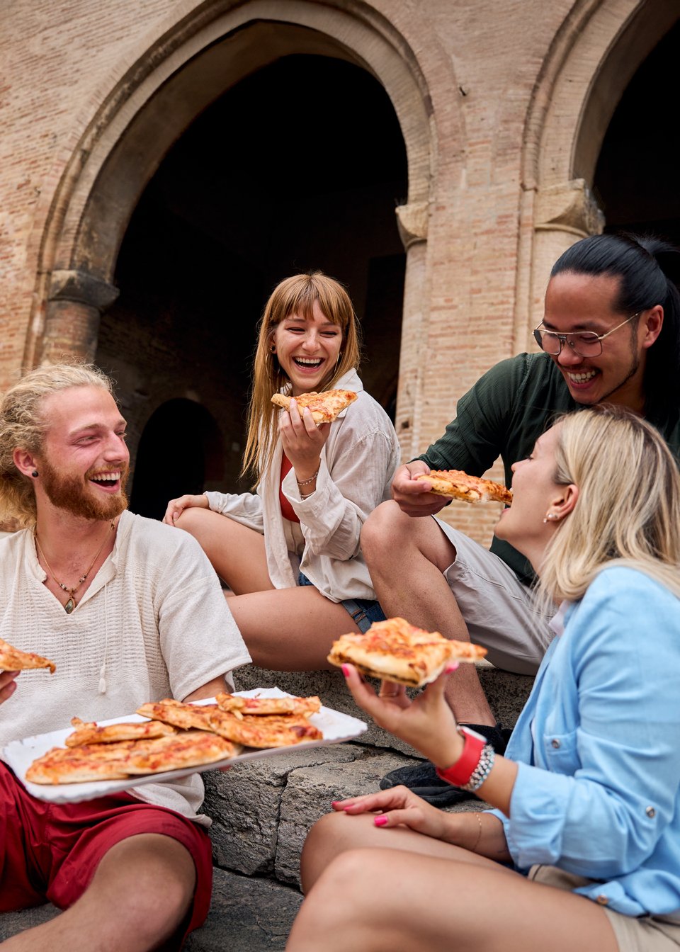 Παρέα ατόμων τρώει πίτσα και διασκεδάζει / Φωτογραφία: Shutterstock  