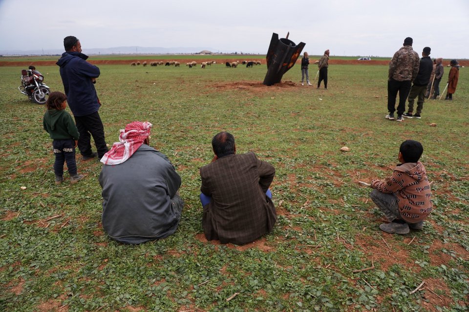 Άνθρωποι στην ανατολική Συρία κοιτάζουν έναν πύραυλο καρφωμένο στο έδαφος / AP Photo, Baderkhan Ahmad