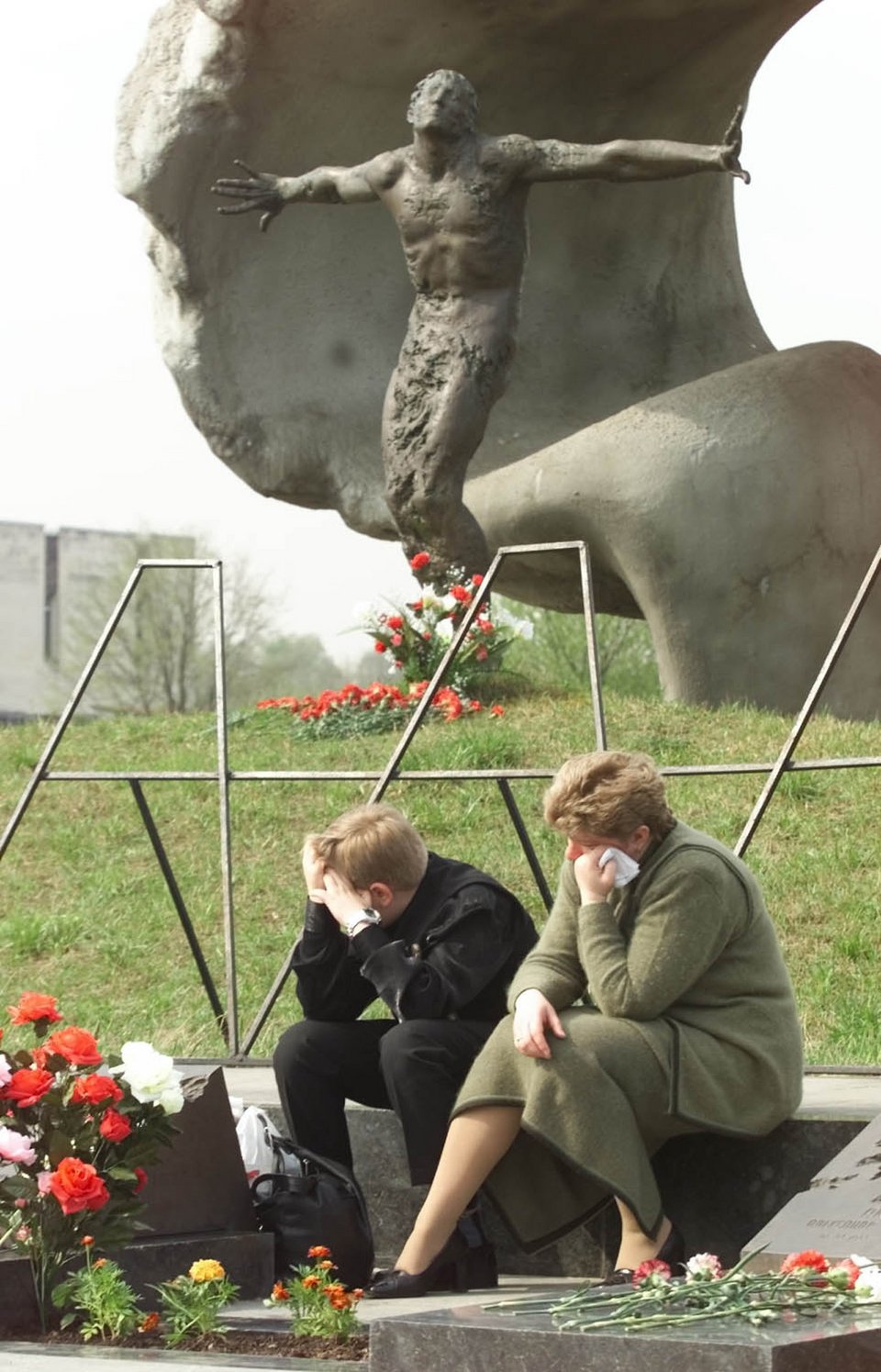 Η σύζυγος και ο γιος του Vasily Ignatenko θρηνούν κοντά στον τάφο του