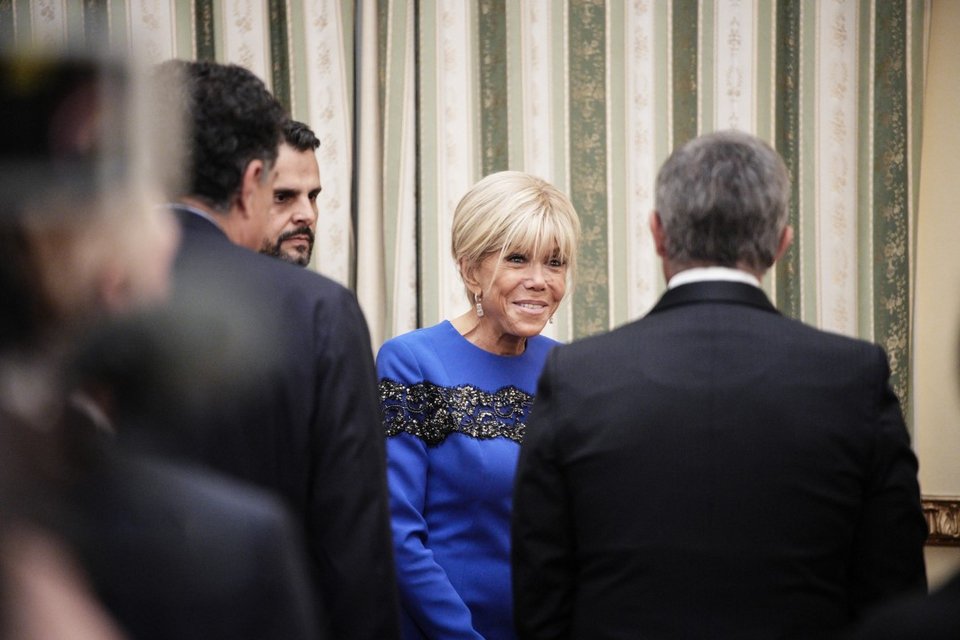 Η Μπριζίτ Μακρόν ευδιάθετη χαιρετάει τους συνδαιτημόνες