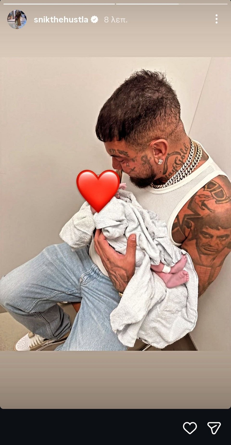 Ο Snik κρατώντας στην αγκαλιά του τη νεογέννητη κόρη του.