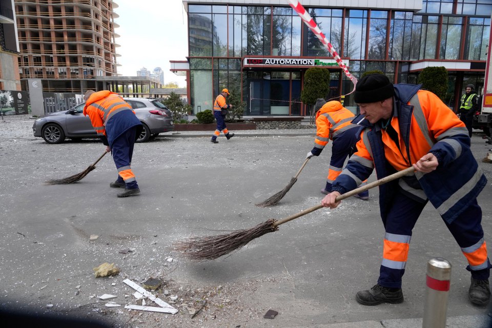 Καθαριστές στο Κίεβο μαζεύουν τα συντρίμμια μετά από ρωσική επίθεση σε κατοικημένη περιοχή / AP
