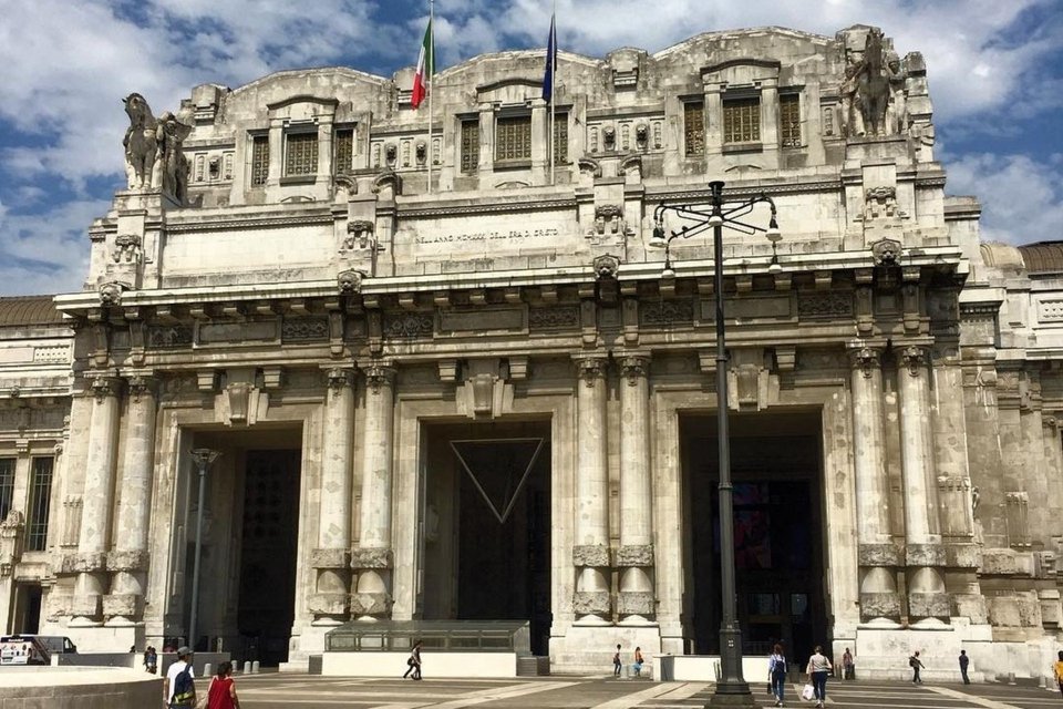 Η Stazione Centrale, με τη γιγαντιαία πρόσοψη, τις ρωμαϊκές κολόνες, τα φτερωτά άλογα, τα λιοντάρια και τα μνημειώδη γλυπτά της, θυμίζει περισσότερο αυτοκρατορικό παλάτι παρά συγκοινωνιακό κόμβο. Για εκατομμύρια τουρίστες αποτελεί σχεδόν αξιοθέατο από μόνη της / WIKIPEDIA