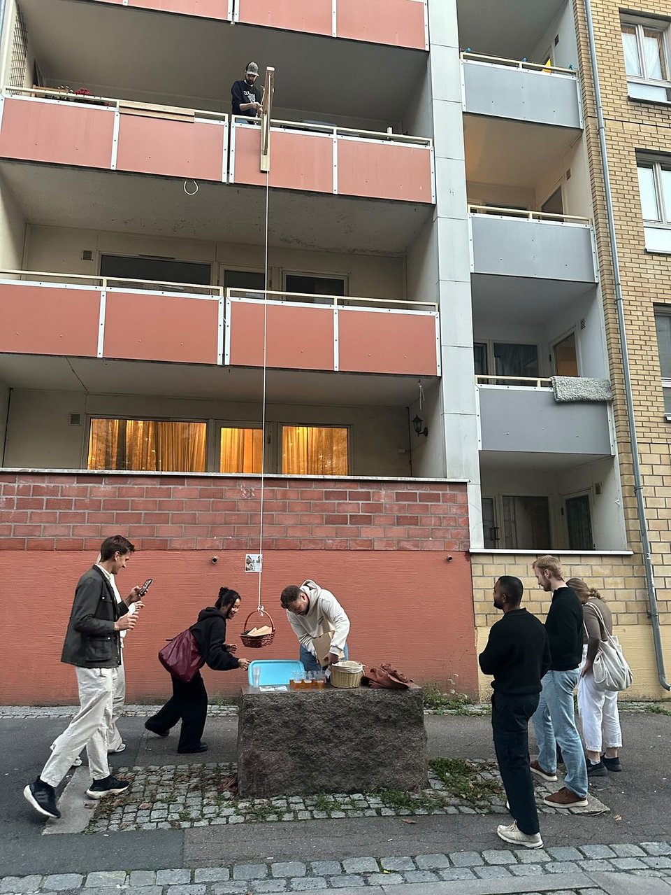 Οι πελάτες που περιμένουν από κάτω, παραλαμβάνουν τις πίτσες τους μέσω μίας τροχαλίας