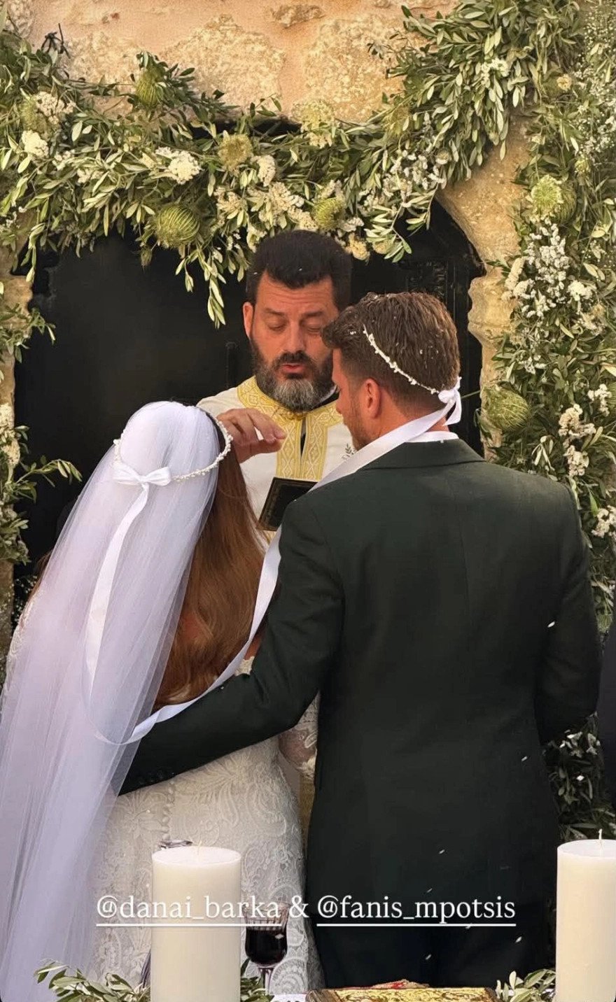 Ο ιερέας που τέλεσε το μυστήριο μαζί με τους νεόνυμφους