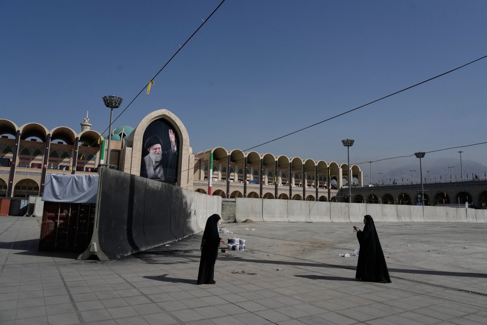 Γυναίκες φωτογραφίζουν στο Μεγάλο Τέμενος Imam Khomeini Mosalla, καθώς βρίσκονται σε εξέλιξη οι προετοιμασίες για τις πολυήμερες τελετές της κηδείας του δολοφονημένου Ανώτατου Ηγέτη του Ιράν, Αγιατολάχ Αλί Χαμενεΐ, που απεικονίζεται στο πανό στο βάθος, στην Τεχεράνη 