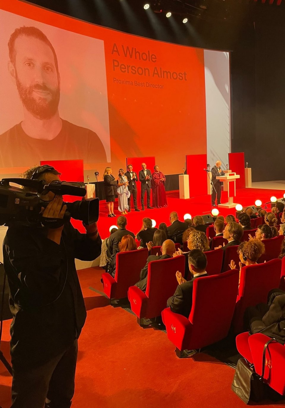 Η ταινία «Ένας Ολόκληρος Άνθρωπος Σχεδόν» τιμήθηκε με το Βραβείο Σκηνοθεσίας του Τμήματος Proxima του 60ού Διεθνούς Φεστιβάλ Κινηματογράφου του Κάρλοβι Βάρι. 