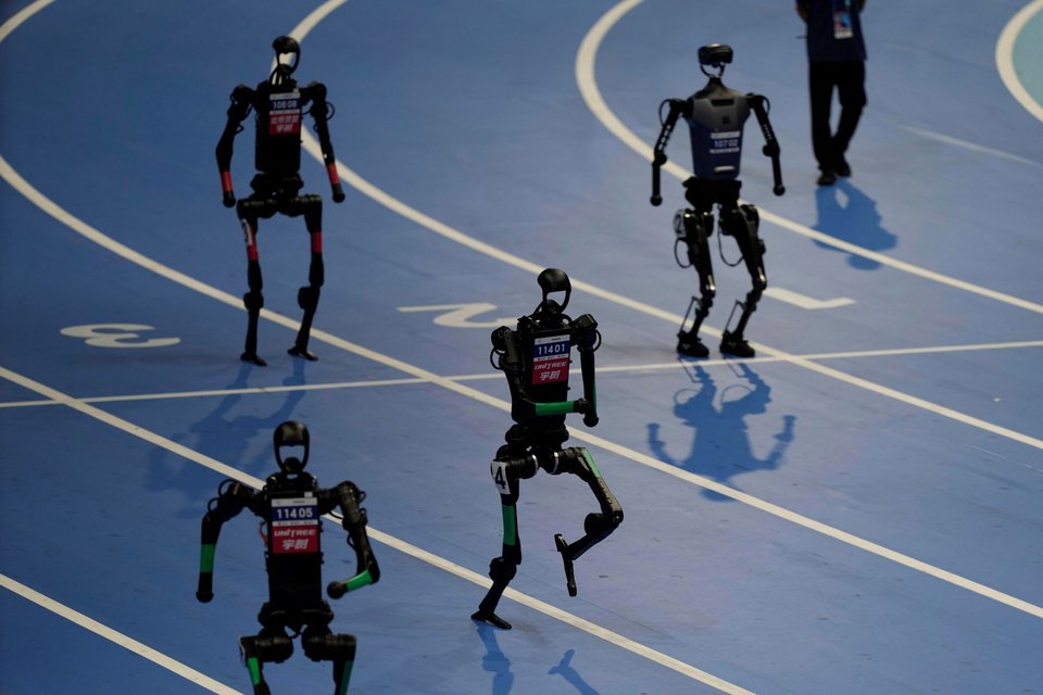 Ρομπότ αγωνίζονται στον τελικό 4x100 μέτρων στους Παγκόσμιους Αγώνες Ανθρωποειδών Ρομπότ στο Πεκίνο της Κίνας, 17 Αυγούστου 2025. (AP Photo/Ng Han Guan)