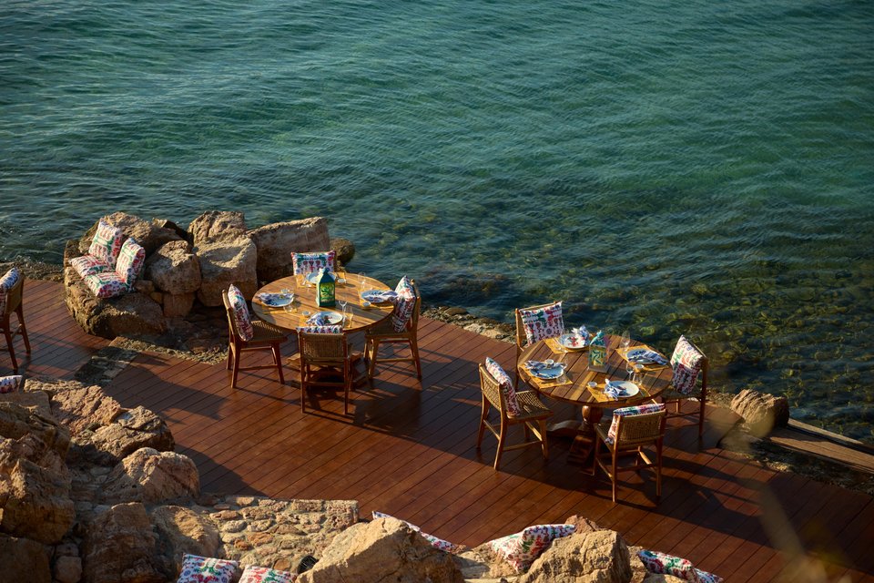 Τα τραπέζια πάνω στο ντεκ με τα βράχια, στη Zolotas Beach στη Βουλιαγμένη