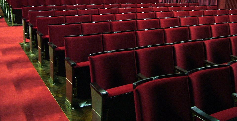 Η εικόνα είναι τόσο συνηθισμένη που σπάνια αναρωτιόμαστε γιατί αυτό το χρώμα μοιάζει να έχει το μονοπώλιο. Τα εστιατόρια, τα αεροπλάνα και τα σαλόνια των σπιτιών χρησιμοποιούν άνετα κάθε λογής αποχρώσεις. Γιατί λοιπόν οι αίθουσες επιστρέφουν πάντα στο ίδιο βαθύ κόκκινο; / UNSPLASH