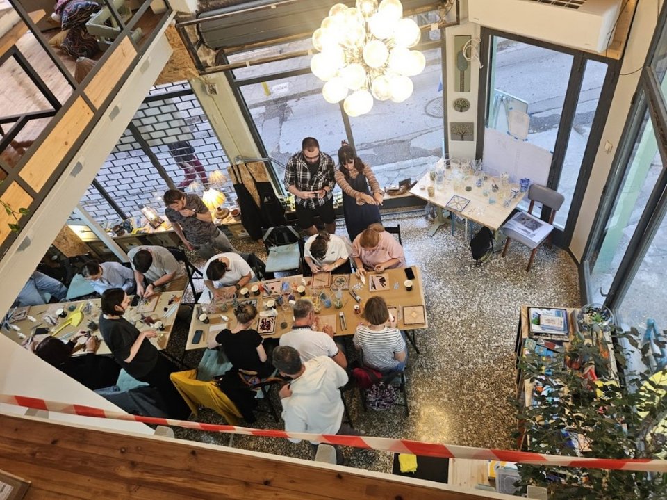 Σε ένα εργαστήριο όπου το γυαλί παίρνει χρώμα, σχήμα και δεύτερη ζωή, οι επισκέπτες αντί να αναζητήσουν το τέλειο αναμνηστικό μαγνητάκι, το κατασκευάζουν οι ίδιοι, ψηφίδα ψηφίδα