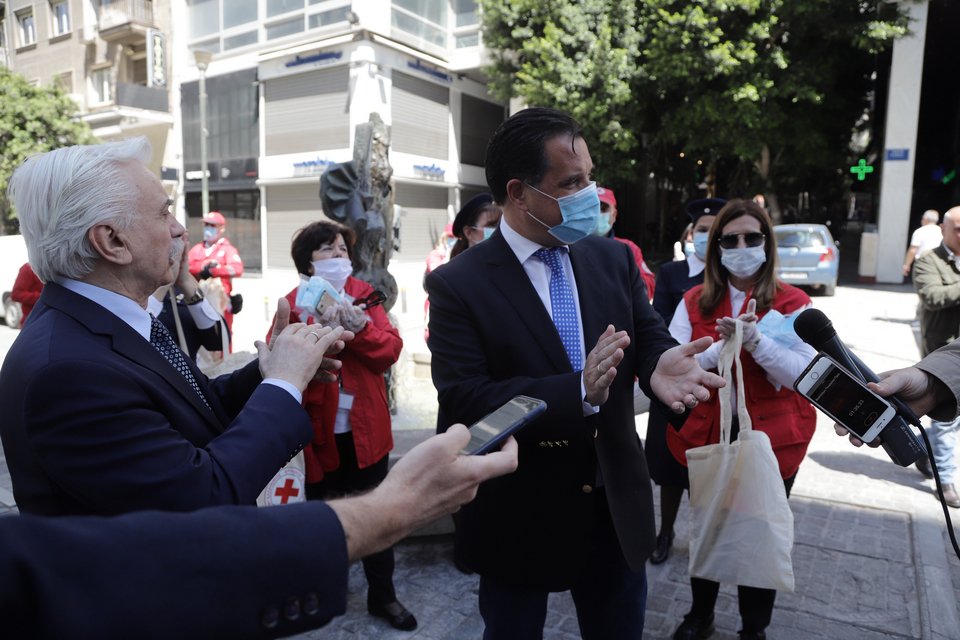Αριστερά, ο πρόεδρος του Ελληνικού Ερυθρού Σταυρού Αντώνης Αυγερινός και ο υπουργός Ανάπτυξης Άδωνις Γεωργιάδης, με εθελοντές, στην Ερμού
