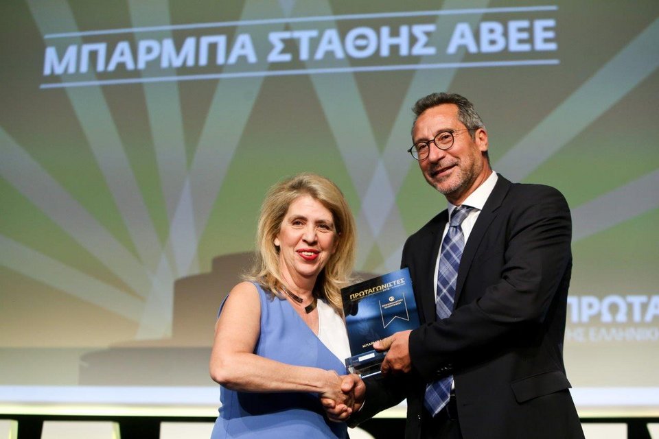 Ο κ. Νικήτας Ποθουλάκης, Αντιπρόεδρος Δ.Σ. & Διευθύνων Σύμβουλος ΜΠΑΡΜΠΑ ΣΤΑΘΗΣ, παραλαμβάνει το βραβείο “Επιχειρηματικής Εξωστρέφειας” στην εκδήλωση «ΠΡΩΤΑΓΩΝΙΣΤΕΣ ΤΗΣ ΕΛΛΗΝΙΚΗΣ ΟΙΚΟΝΟΜΙΑΣ» από την κ. Χ. Απαλαγάκη, Γ. Γραμματέα της Ελληνικής Ένωσης Τραπεζών