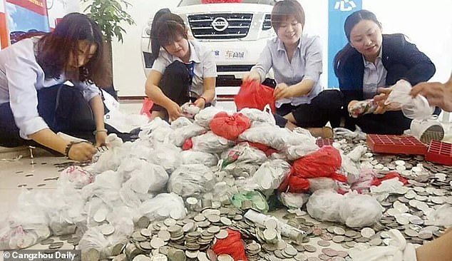 Υπάλληλοι μετρούν με τα χέρια, τα χιλιάδες νομίσματα / Φωτογραφία: Cangzhou Daily