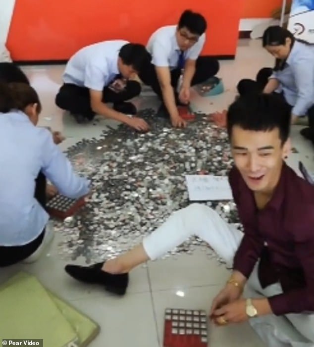 Οι υπάλληλοι κάθονται στο πάτωμα και μετρούν τα χιλιάδες κέρματα