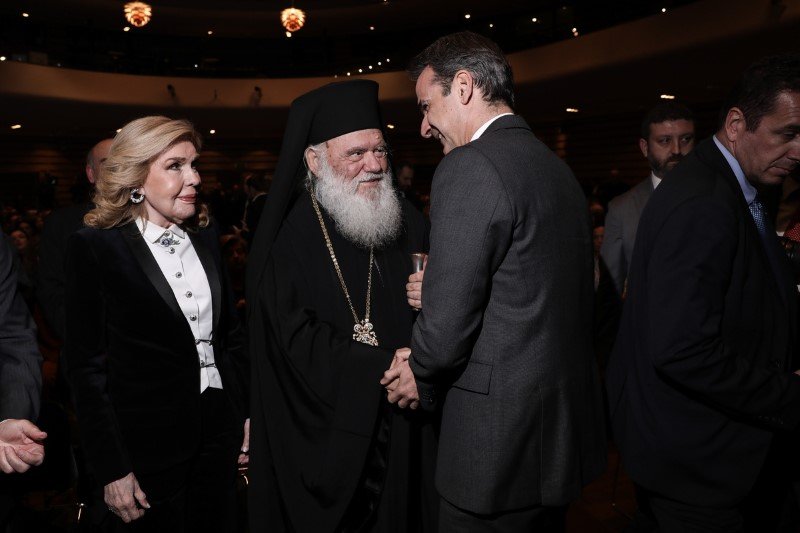 Ο Κυριάκος Μητσοτάκης χαιρετά το αρχιεπίσκοπο Ιερώνυμο υπό το βλέμμα της Μαριάννας Β. Βαρδινογιάννη