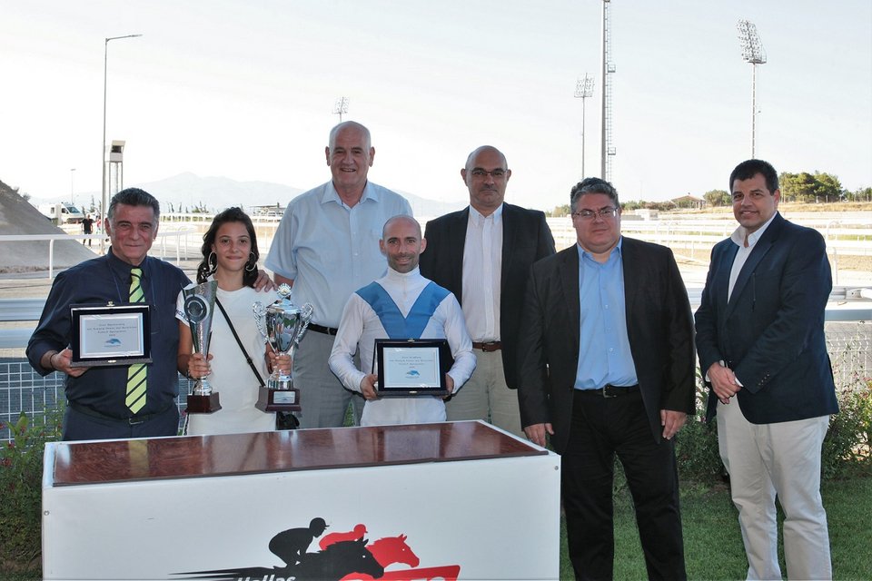 Από αριστερά ο εκπρόσωπος των Στάβλων ΚΟΥΪΝΣ ΓΟΥΕΪ Βασίλης Κεράτσας, η κόρη της προπονήτριας Ειρήνης Κεράτσα, ο Διευθυντής Τεχνικών Υπηρεσιών της ΙΠΠΟΔΡΟΜΙΕΣ Α.Ε.  Γιώργος Αγγελόπουλος, ο αναβάτης Γιάννης Λαζαρίδης, ο Racing Manager της ΙΠΠΟΔΡΟΜΙΕΣ Α.Ε. Κωνσταντίνος Λουκόπουλος, ο Γενικός Επιχειρησιακός Διευθυντής της ΙΠΠΟΔΡΟΜΙΕΣ Α.Ε. Κωνσταντίνος Αλεξόπουλος και το μέλος της Επιτροπής Ιπποδρομιών Σέργιος Σπασσώφ