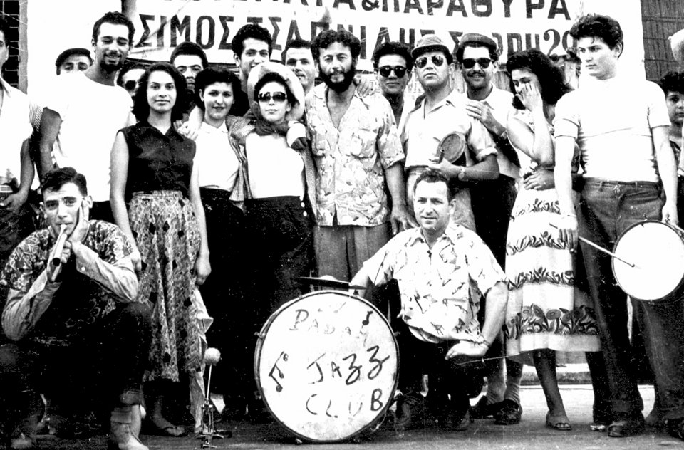 Συγκέντρωση υπαρξιστών μπροστά στην Ιπτάμενη Παράγκα. Είναι έτοιμοι να επιβιβαστούν σε φορτηγά για εκδρομή στο Ζούμπερι. Φαίνεται το μεγάλο τύμπανο από την ντραμς του υπαρξιστικού τους συγκροτήματος Padam Jazz Club