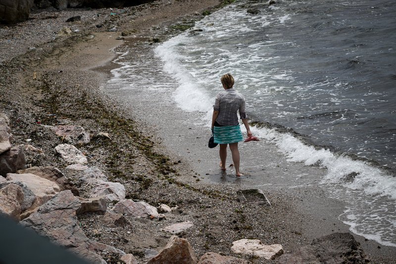 Γυναίκα περπατά στη θάλασσα, στην παραλία του Παλαιού Φαλήρου