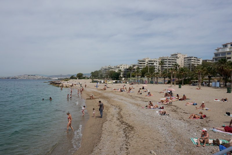 Κόσμος κάνει μπάνιο και ηλιοθεραπεία σε παραλία της Αττικής