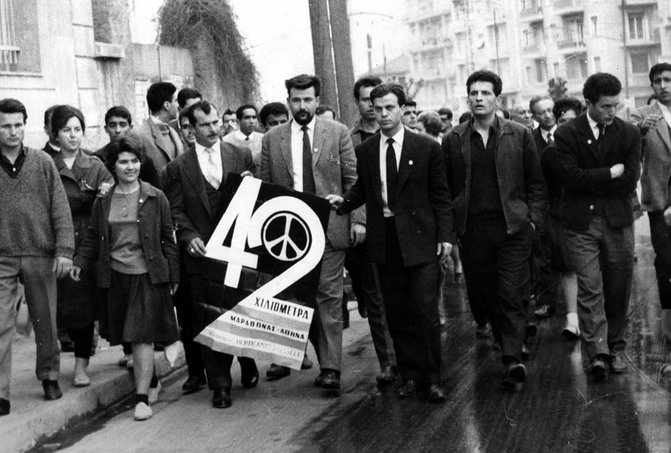Οι πρώτες ομάδες ξεκινούν ξημερώματα και κατευθύνονται στη Λεωφόρο Αλεξάνδρας. Στο κέντρο μιας τέτοιας ομάδας, βλέπουμε τον Πατ Ποτλ, γραμματέα του Μπέρταρντ Ράσελ (με το μούσι) ο οποίος έχει έρθει από την Αγγλία για να συμμετάσχει στην Πορεία. Ο νεαρός, δίπλα του, με την γραβάτα, είναι ο πρόεδρος του ελληνικού Συνδέσμου, Μιχάλης Περιστεράκης.