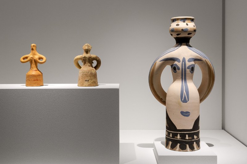 Από αριστερά: γυναικείο ειδώλιο (περίπου 1400-1300 π.Χ.), γυναικείο ειδώλιο (περίπου 1750-1500 π.Χ.), «Ο Βασιλιάς» έργο του Πικάσο από λευκό πηλό/ Φωτογραφία Πάρις Ταβιτιάν Μουσείο Κυκλαδικής Τέχνης