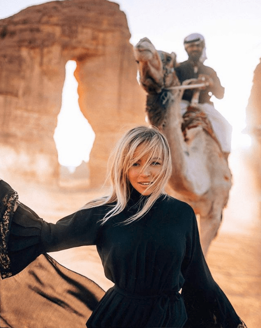 Influencer ποζάρει στην έρημο της Σαουδικής Αραβίας με έναν καμηλιέρη πίσω
