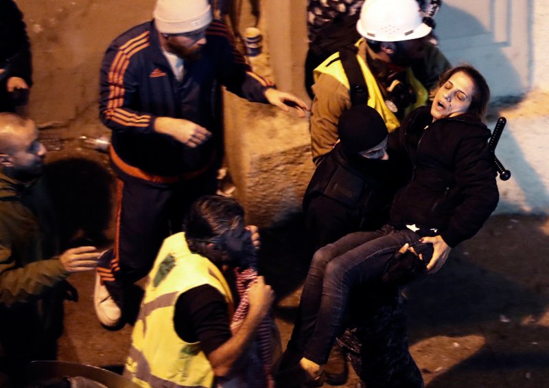 Διαδηλωτής μεταφέρει γυναίκα που τραυματίστηκε κατά τη βίαιη καταστολή της συγκέντρωσης.