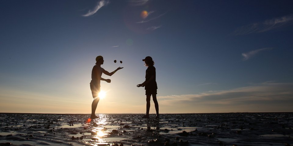 Tουρίστες βολτάρουν στη θάλασσα Βάντεν από το νησί Λάνγκενες στο Ντάγκεμπουλ της βόρειας Γερμανίας / Φωτογραφία αρχείου: AP Photo