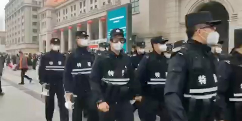 Αστυνομικοί με μάσκες περιπολούν σε δρόμο του Βουχάν.