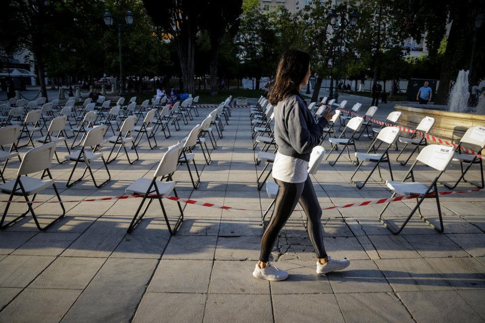 Περαστική παρακολουθεί με απορία τις άδειες καρέκλες της ΠΟΕΣΕ στο Σύνταγμα