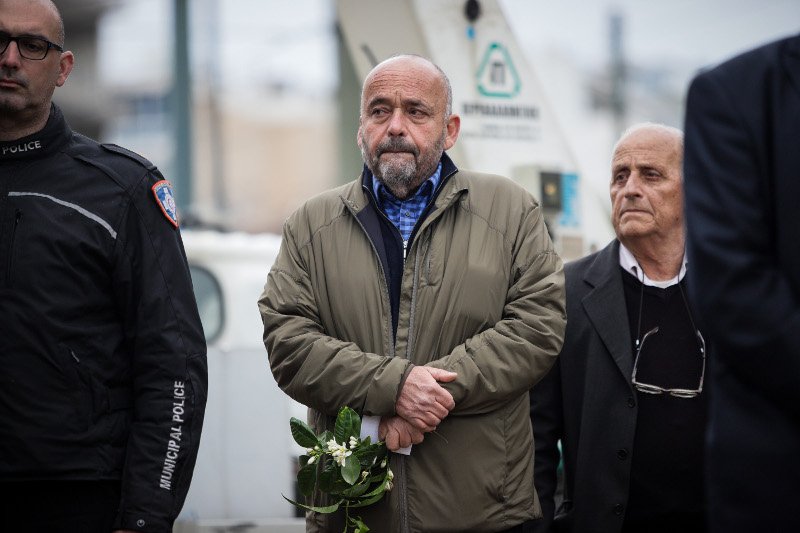 Συγκινημένος ο Αλέξανδρος Παππάς, γιος του γλύπτη Γιάννη Παππά, κρατά λίγα λουλούδια στα χέρια