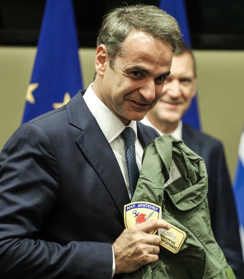 Ο Κ. Μητσοτάκης δείχνει το όνομά του στην στολή πιλότου μαχητικού που του χάρισε ο ΑΓΕΕΘΑ