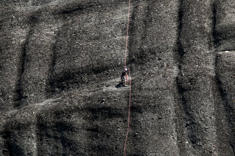 Οι -σχεδόν κάθετοι- σκουρόχρωμοι βράχοι που στέκονται ολόρθοι στην κοιλάδα της Καλαμπάκας -