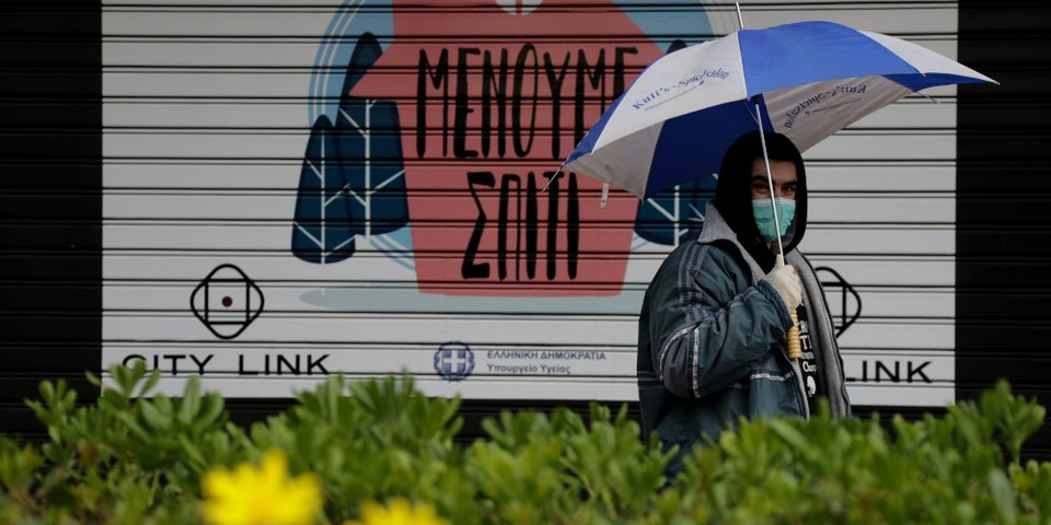 Ανδρας στην Αθήνα μπροστά σε πινακίδα «Μένουμε Σπίτι» / Φωτογραφία: Eurokinissi