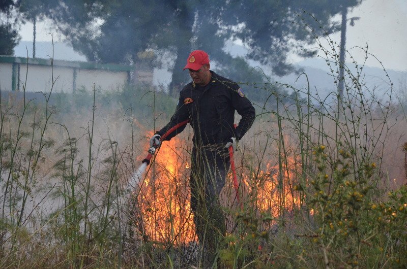 Πυροσβέστης επιχειρεί κατάσβεση φωτιάς που ξέσπασε από κεραυνό