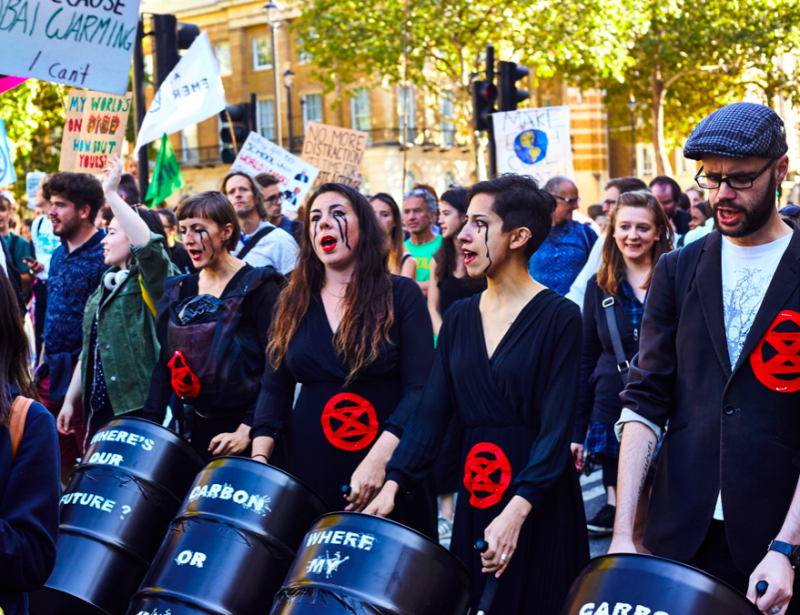 Αριστερά η Bythe Pepino, ιδρύτρια του κινήματος BirthStrike. Οι γυναίκες φοράνε το έμβλημα Extinction Rebellion, σύμβολο της «απεργίας μήτρας», όπως το αποκαλούν. Στα καροτσάκια, βαρέλια πετρελαίου αντί για μωρά/ Twitter @BirthStrike