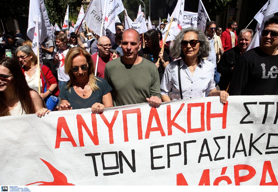Δανάη Στράτου και Γιάνης Βαρουφάκης στην πορεία, κρατώντας πανό