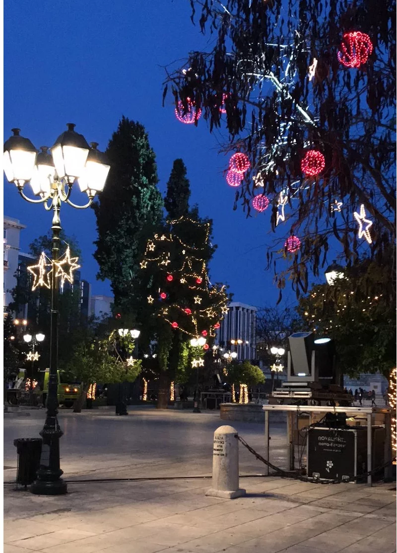 Κόκκινες μπάλες από φωτάκια και λευκά αστέρια στολίζουν τα δέντρα της πλατείας Συντάγματος