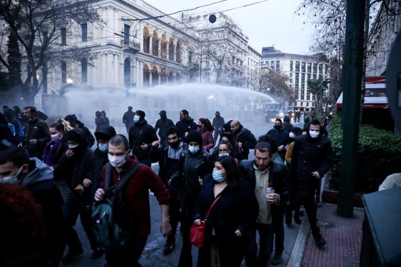 Διαδηλωτές απομακρύνονται από την οδό Πανεπιστημίου μετά τη ρίψη νερού από την αστυνομία