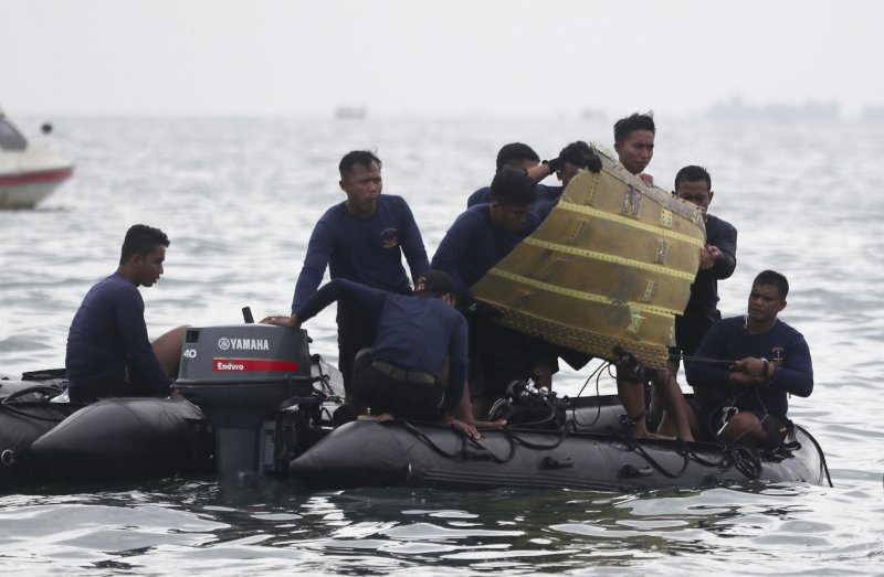 Διασώστες μεταφέρουν ένα κομμάτι του αεροπλάνου