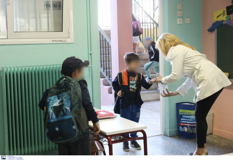 Δασκάλα βάζει αντισηπτικό σε μαθητή
